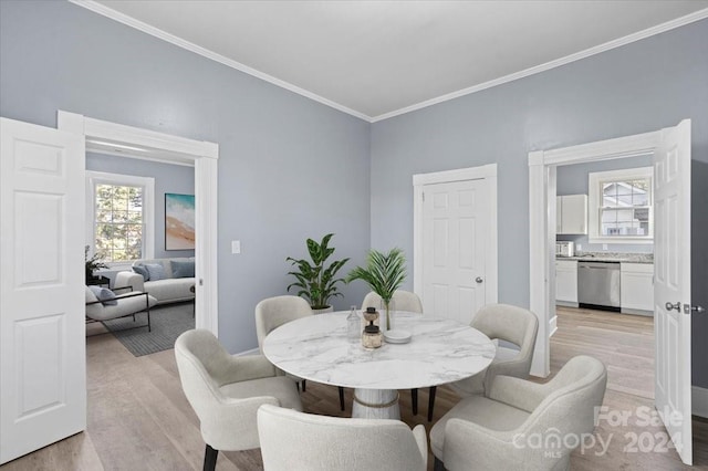 dining area with crown molding and light hardwood / wood-style floors