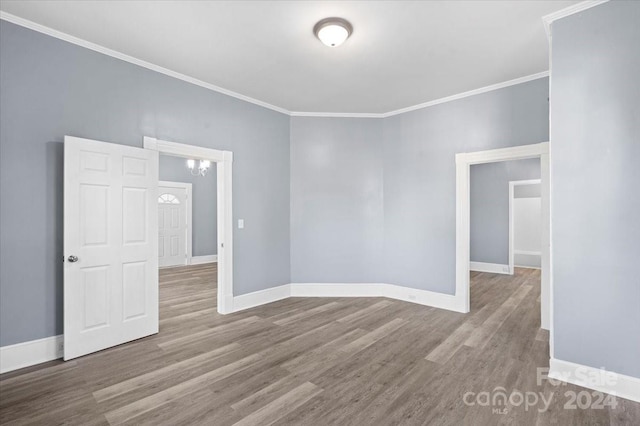 empty room featuring ornamental molding and hardwood / wood-style floors