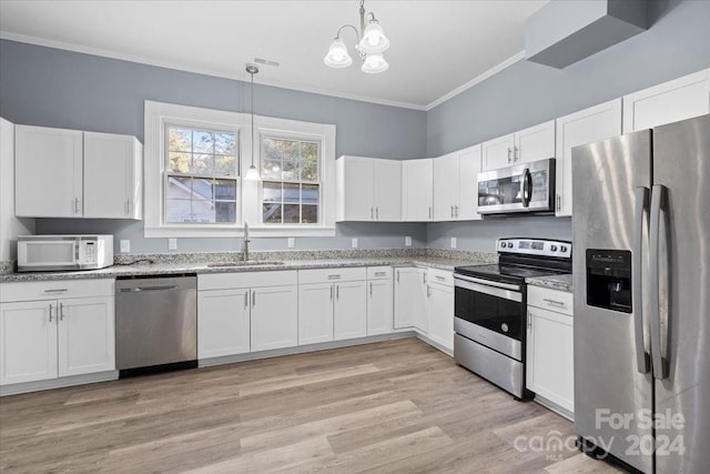 kitchen featuring white cabinetry, stainless steel appliances, hanging light fixtures, and sink