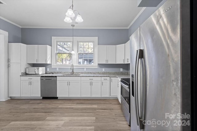 kitchen featuring sink, appliances with stainless steel finishes, decorative light fixtures, and white cabinetry