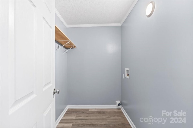 washroom with hookup for a washing machine, a textured ceiling, wood-type flooring, and crown molding