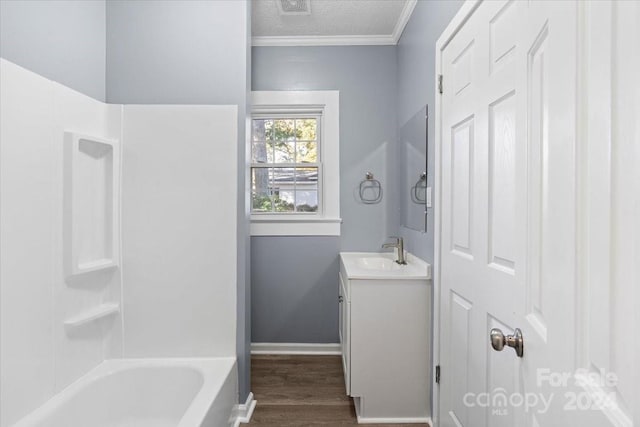 bathroom with vanity, hardwood / wood-style flooring, a textured ceiling, and ornamental molding