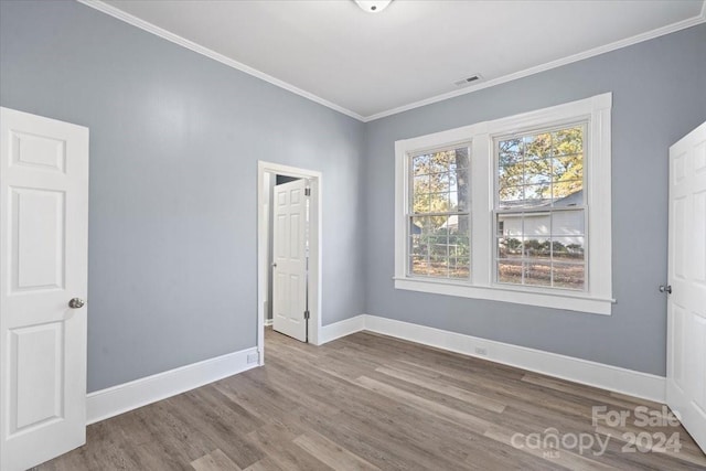 spare room with hardwood / wood-style flooring and ornamental molding