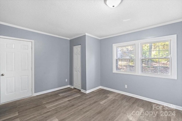 unfurnished bedroom with dark wood-type flooring, crown molding, and a textured ceiling