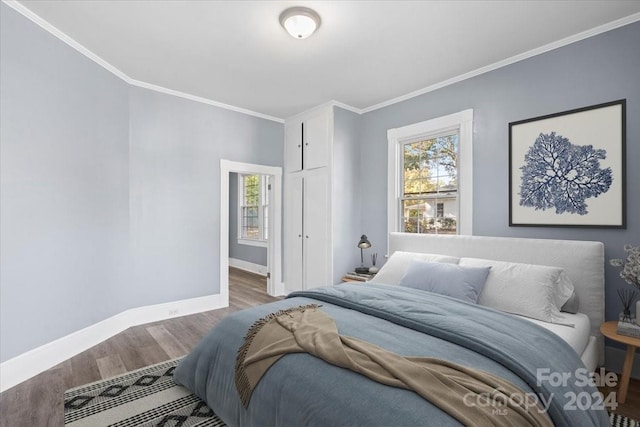 bedroom featuring ornamental molding and hardwood / wood-style floors