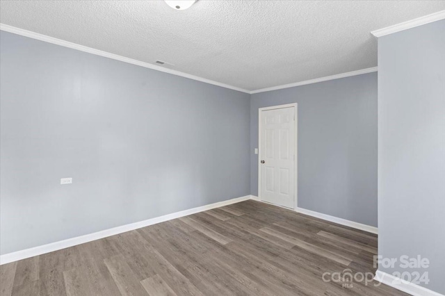 empty room with dark wood-type flooring, crown molding, and a textured ceiling