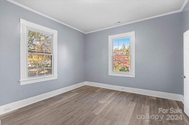 spare room with ornamental molding and wood-type flooring