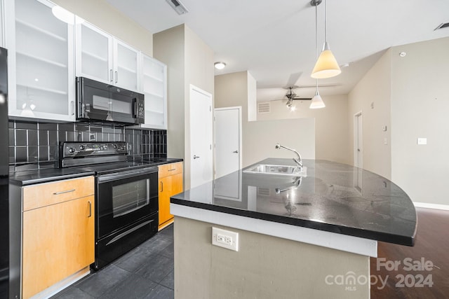 kitchen featuring sink, black appliances, backsplash, an island with sink, and hanging light fixtures