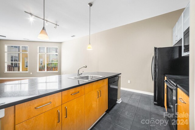 kitchen with sink, black appliances, rail lighting, hanging light fixtures, and dark tile patterned flooring