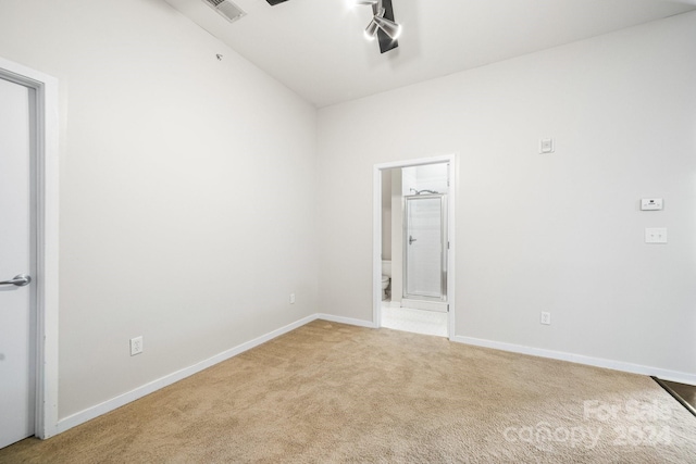 empty room with light colored carpet and lofted ceiling