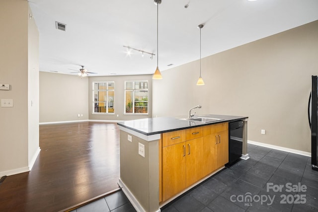 kitchen featuring visible vents, ceiling fan, a center island with sink, a sink, and black appliances