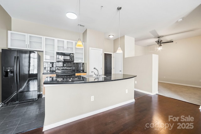 kitchen with backsplash, a sink, white cabinetry, dark countertops, and black appliances