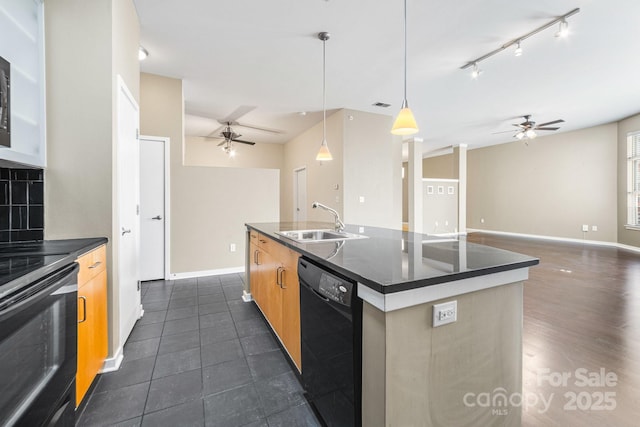 kitchen with dark countertops, black appliances, a sink, and a ceiling fan