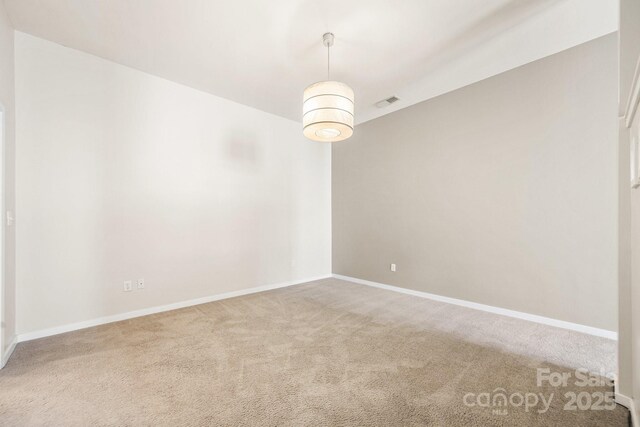 carpeted empty room featuring baseboards