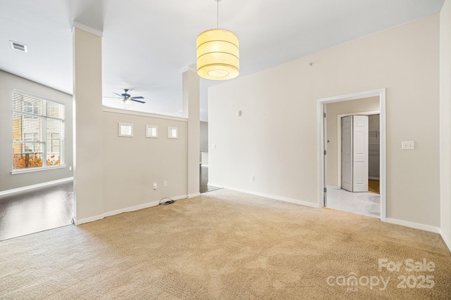 unfurnished living room featuring baseboards, carpet floors, visible vents, and a ceiling fan