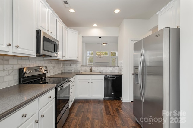 kitchen with tasteful backsplash, sink, white cabinets, hanging light fixtures, and stainless steel appliances