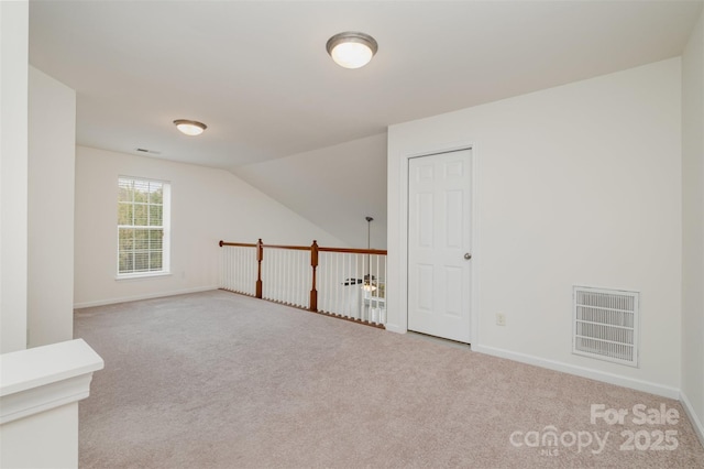 additional living space with light carpet and vaulted ceiling