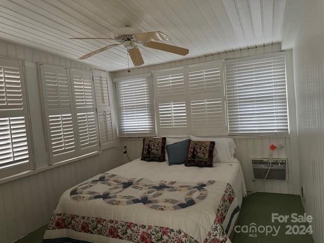 bedroom with ceiling fan and an AC wall unit