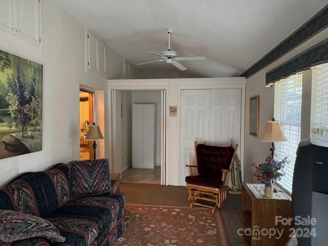 living room with ceiling fan, carpet, and vaulted ceiling