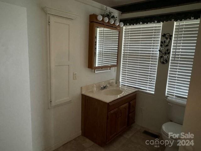 bathroom featuring vanity, toilet, and tile patterned flooring