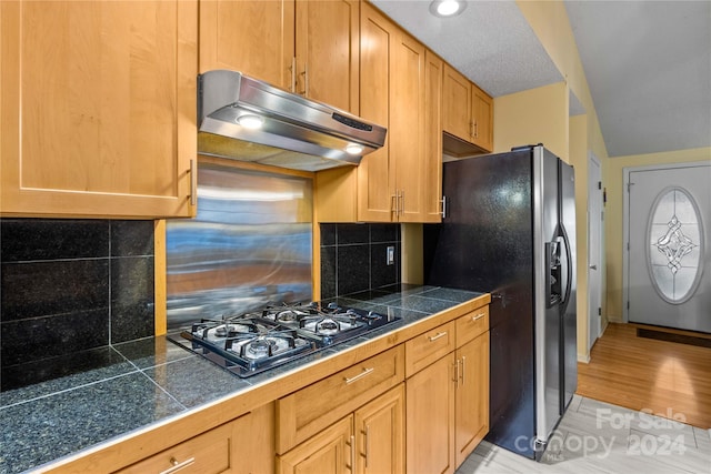 kitchen with tasteful backsplash, light hardwood / wood-style flooring, and black appliances