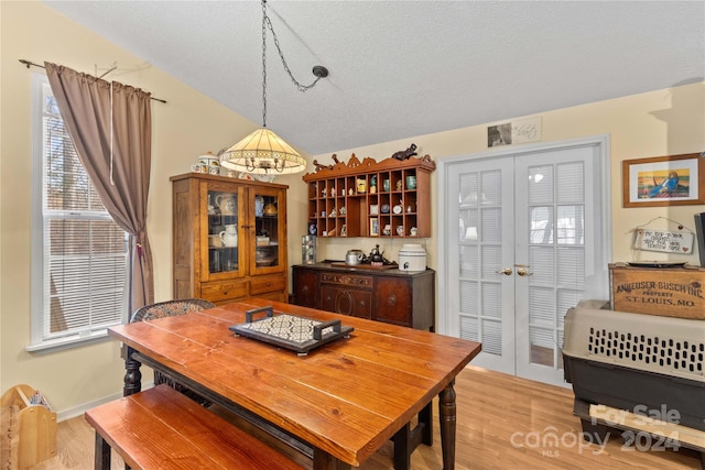 dining area featuring a chandelier, a textured ceiling, and light hardwood / wood-style floors