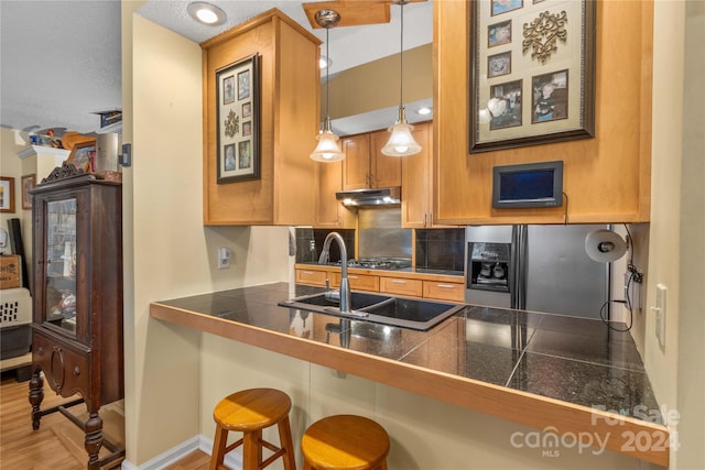 kitchen with pendant lighting, a kitchen breakfast bar, light wood-type flooring, and kitchen peninsula