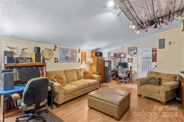 living room featuring hardwood / wood-style floors, lofted ceiling, and a textured ceiling