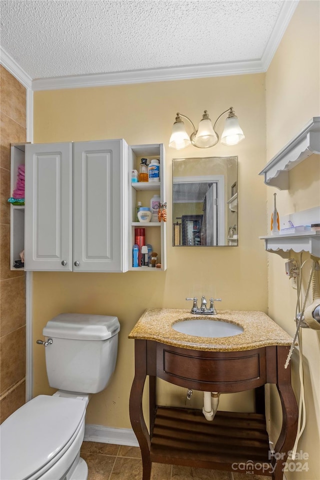 bathroom with toilet, tile patterned flooring, a textured ceiling, and ornamental molding