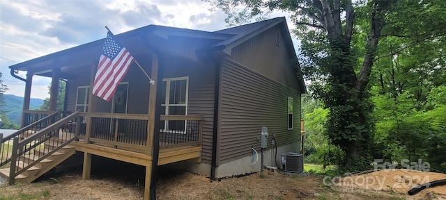 view of home's exterior featuring central AC unit and a deck with mountain view