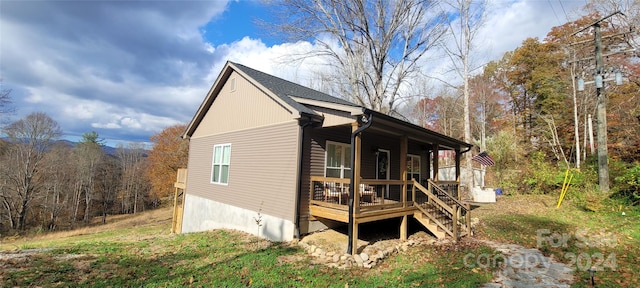 view of side of home featuring covered porch