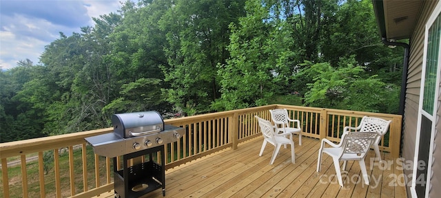 wooden deck featuring a grill