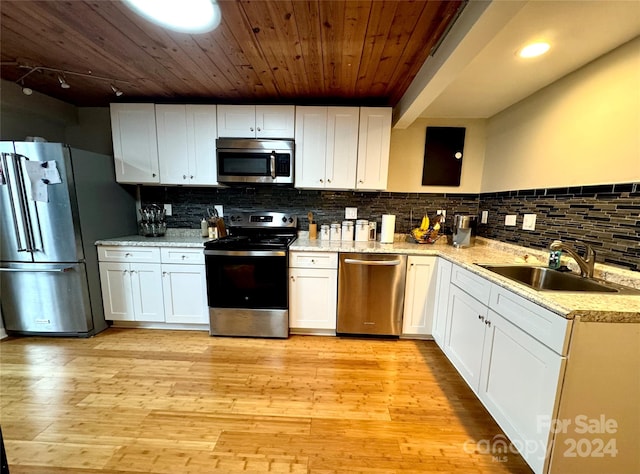 kitchen with decorative backsplash, white cabinets, sink, light hardwood / wood-style floors, and stainless steel appliances