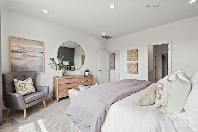 bedroom with light colored carpet and connected bathroom