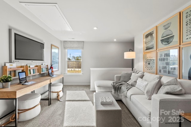 carpeted living area featuring attic access and baseboards