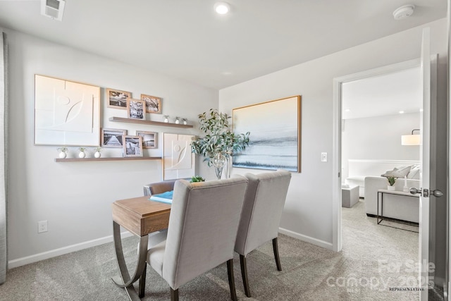 carpeted dining space with visible vents and baseboards