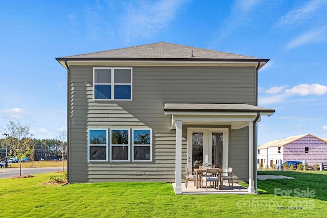 back of property with french doors, a lawn, and a patio