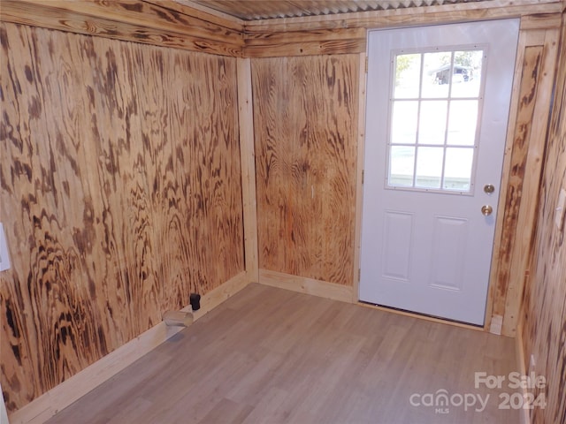 clothes washing area featuring wood-type flooring and wood walls