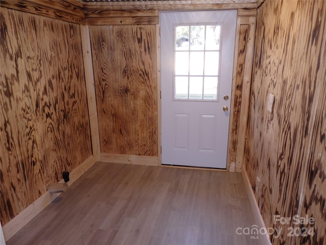 doorway to outside with wooden walls and wood-type flooring