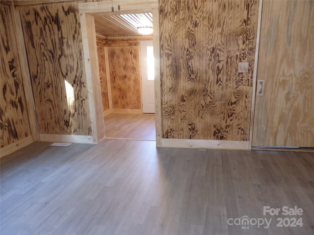 unfurnished room with hardwood / wood-style flooring and wood walls