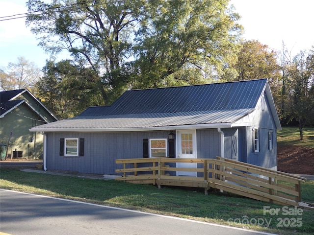 view of front of home featuring metal roof and a wooden deck