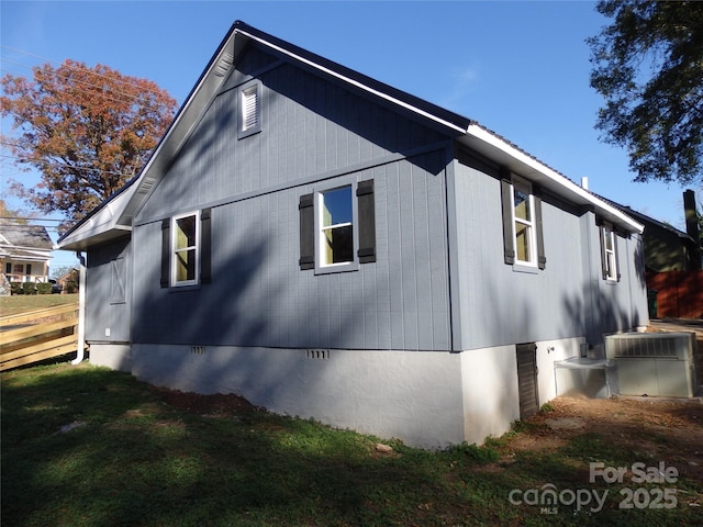 view of side of home featuring a yard, crawl space, and central AC