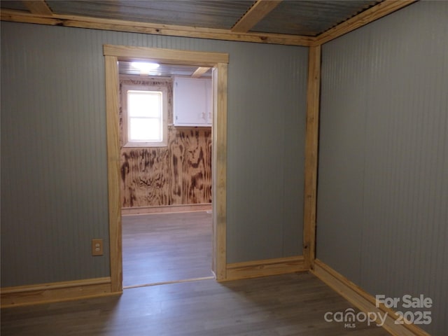 unfurnished room featuring baseboards and wood finished floors