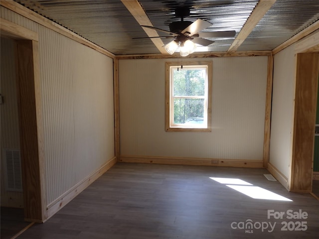 spare room with visible vents, baseboards, wood finished floors, and ceiling fan