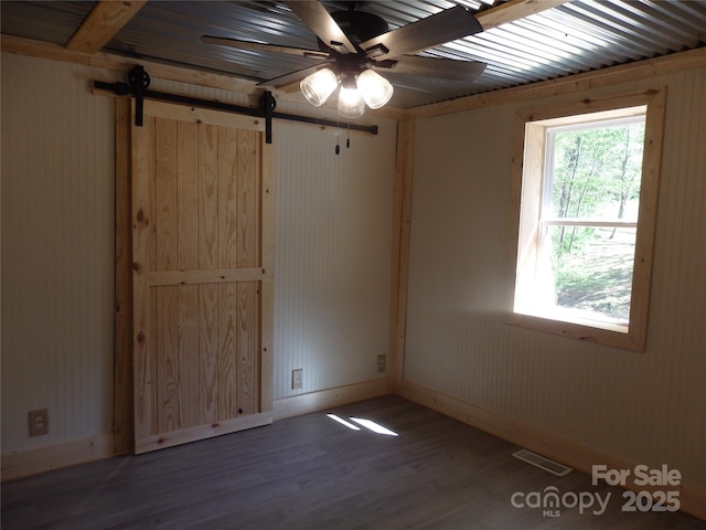 spare room with visible vents, baseboards, a ceiling fan, and wood finished floors