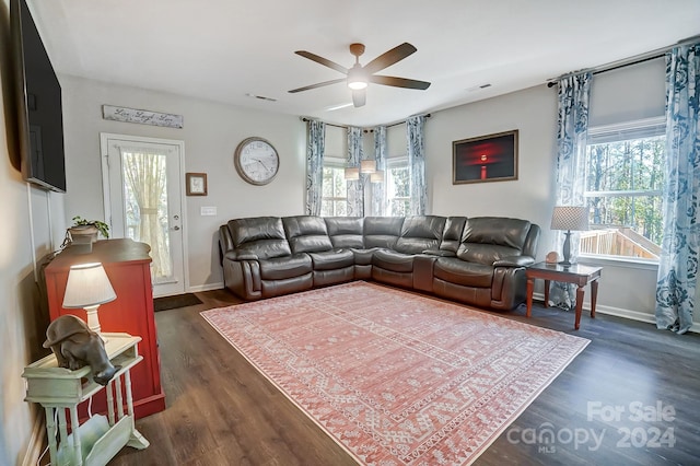 living room featuring ceiling fan and dark wood-type flooring