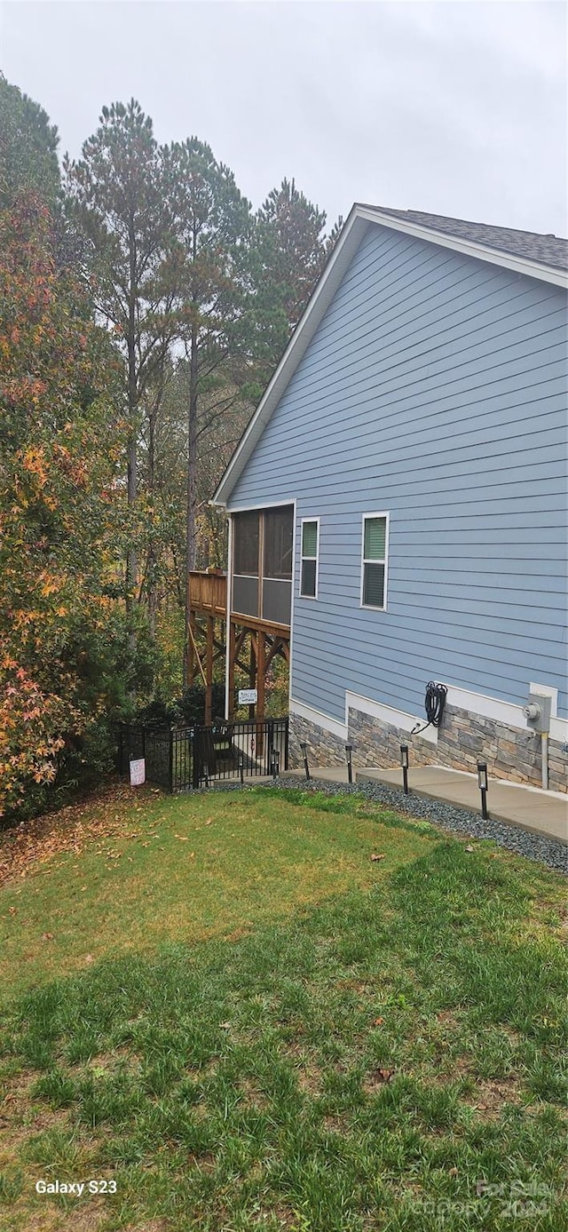 view of home's exterior featuring a sunroom and a yard