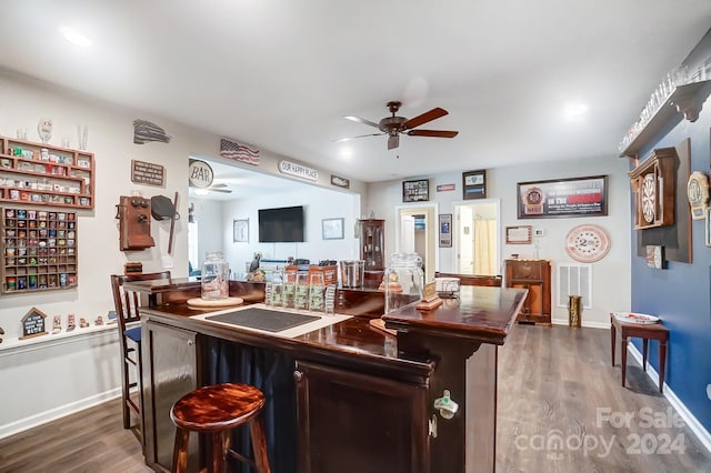 bar with ceiling fan and dark wood-type flooring