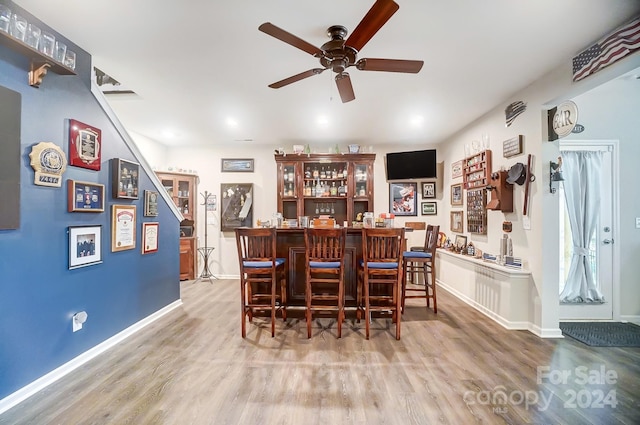 bar featuring ceiling fan and hardwood / wood-style floors