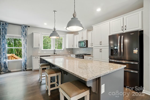 25622 Seagull Dr Unit 645, Lancaster, SC 29720 - kitchen with stainless steel appliances, decorative backsplash, dark wood-style flooring, white cabinetry, and a kitchen island